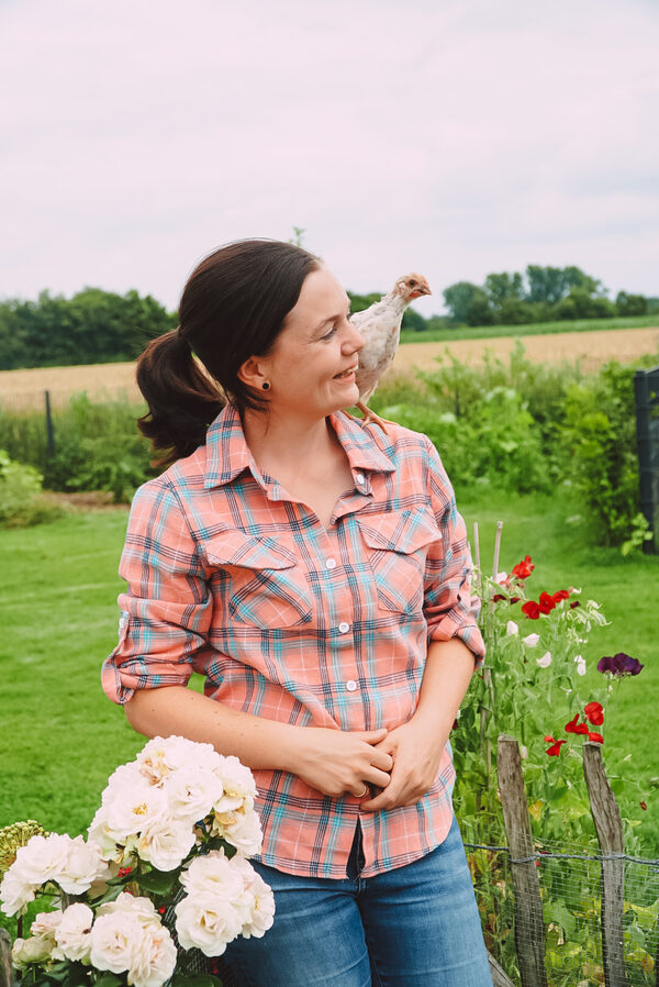 Dr. Eva-Maria Casteel mit einer Henne im Garten